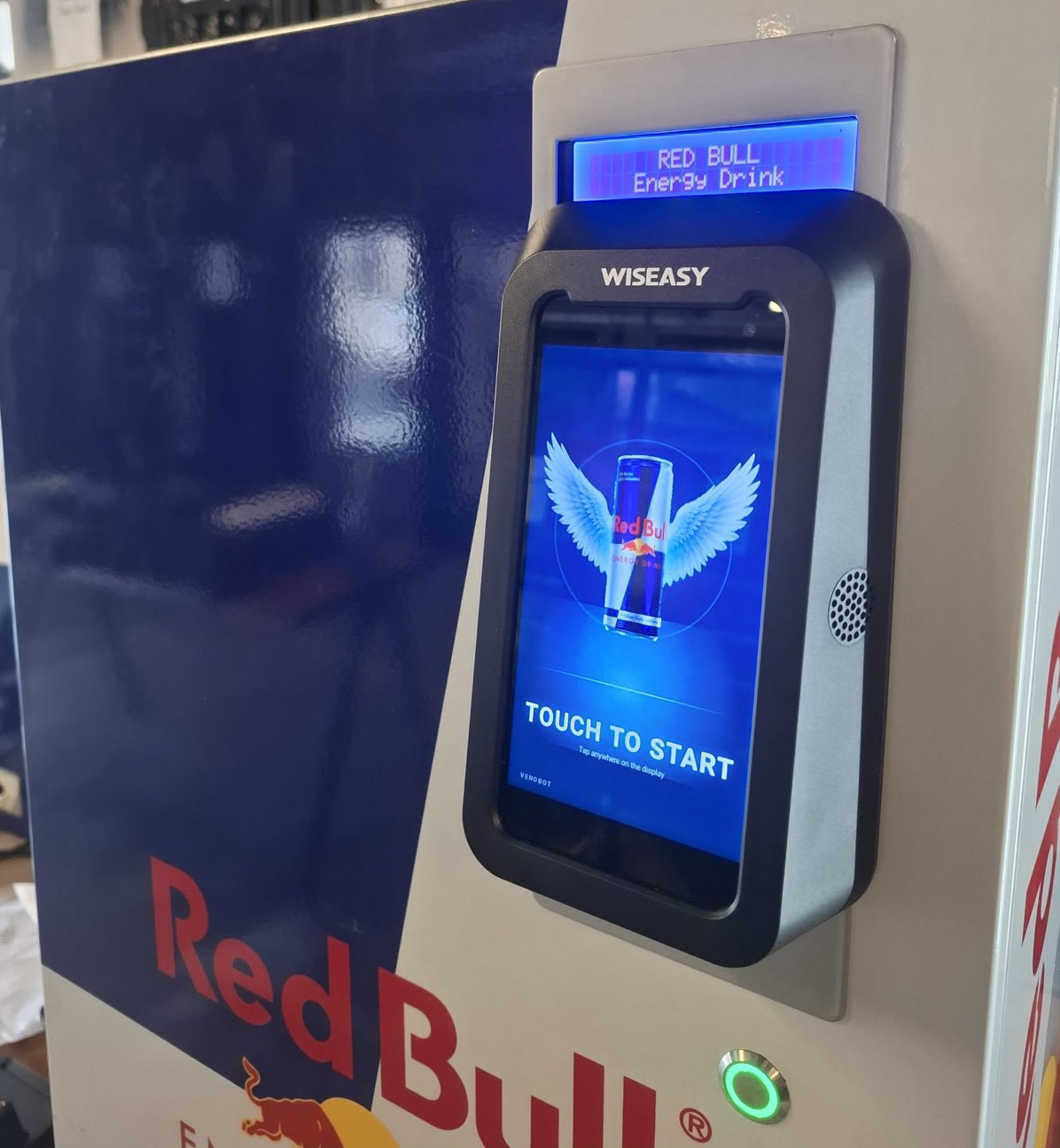 Close-up of the Red Bull-branded idle screen on a VendBot P5L payment terminal, reading Touch to Start